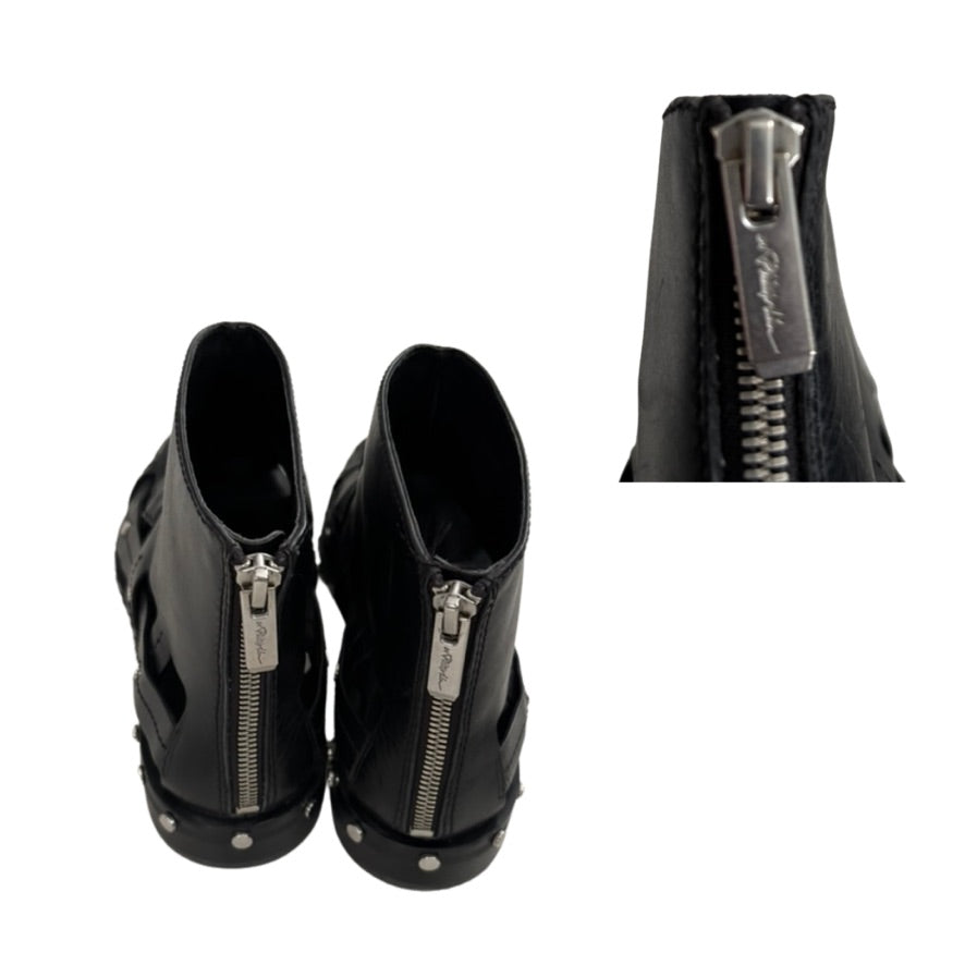 Black high-heeled shoes with zippers on a white background