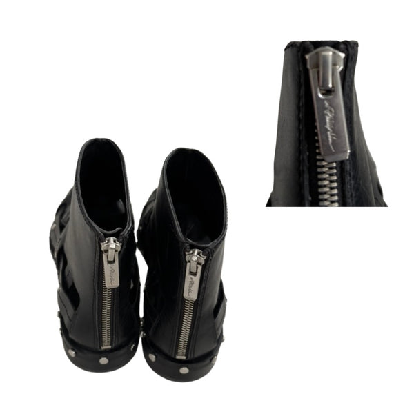 Black high-heeled shoes with zippers on a white background
