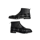 Black rubber boots with stud detailing on a white background