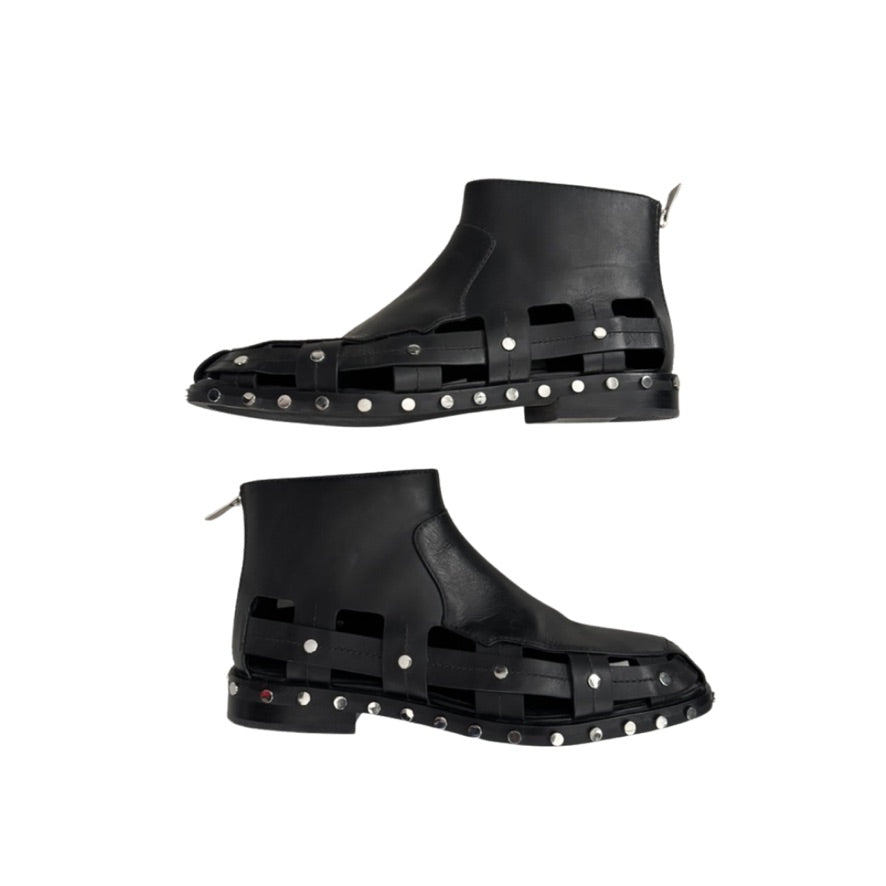 Black rubber boots with stud detailing on a white background