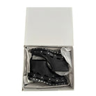 Black studded boots in a white box on a white background