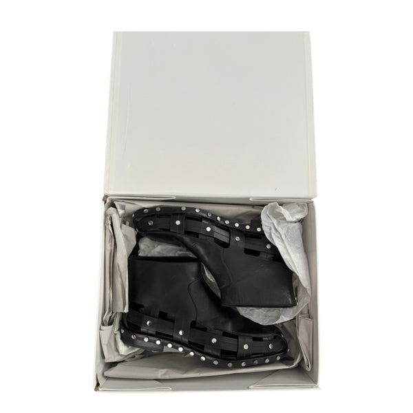 Black studded boots in a white box on a white background