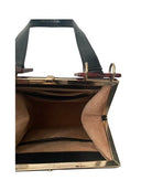 Close-up of a handbag with gold frame and black handle on a white background