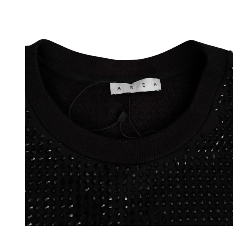 Black sweater with rhinestone details and 'AREA' label on a white background