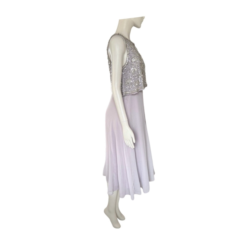 Mannequin wearing a silver sequined top and light purple skirt on a white background
