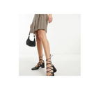 Person wearing black lace-up high heels on a white background