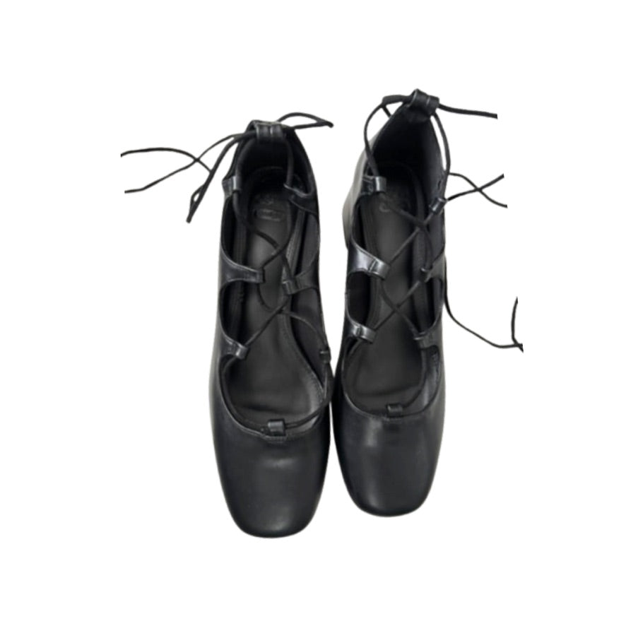 Pair of black leather shoes with criss-cross laces on a white background