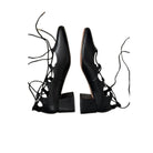 Pair of black lace-up high-heeled shoes on a white background