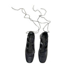 Pair of black ballet shoes with a white background
