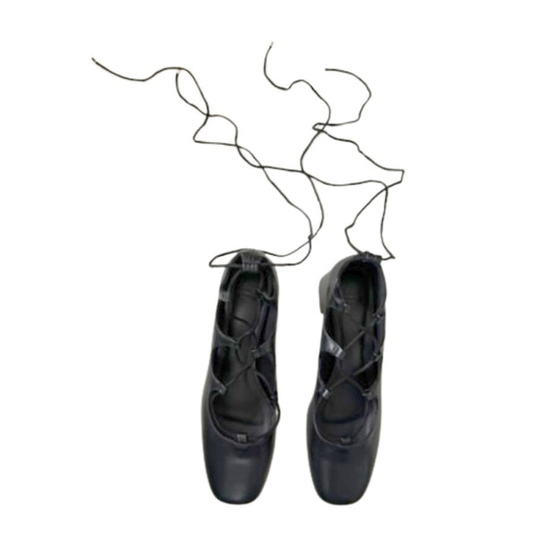 Pair of black ballet shoes with a white background