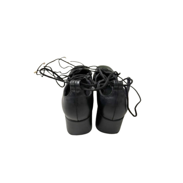 Pair of black dance shoes with laces on a white background