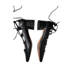 Black high-heeled shoes with unique design on a white background