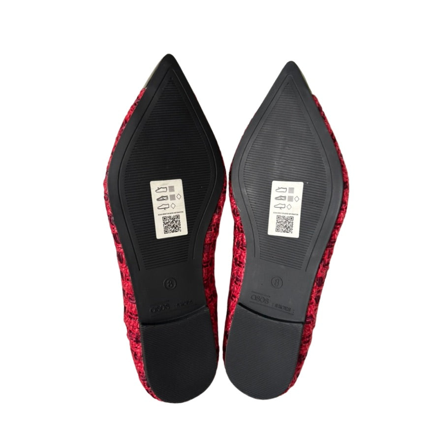 Red and black pointed-toe shoes on a white background