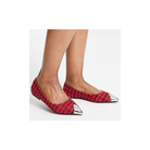 Red patterned shoes with silver toes worn by a person on a white background