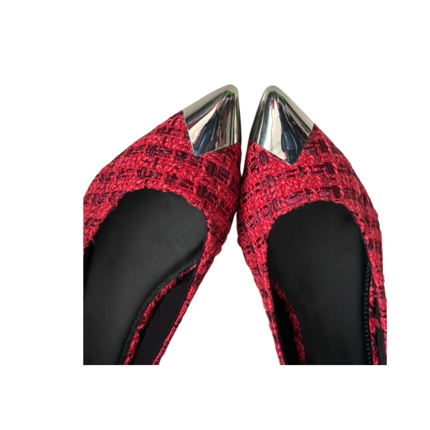 Red patterned shoes with silver pointed toes on a white background
