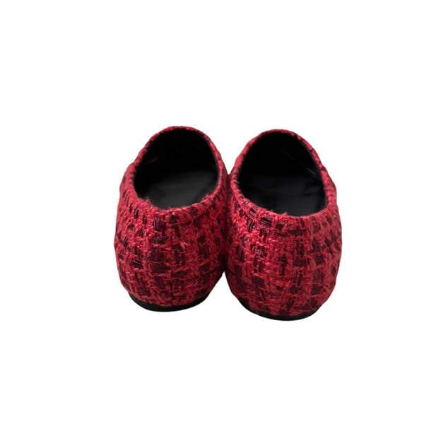 Pair of red flat shoes with a pattern on a white background