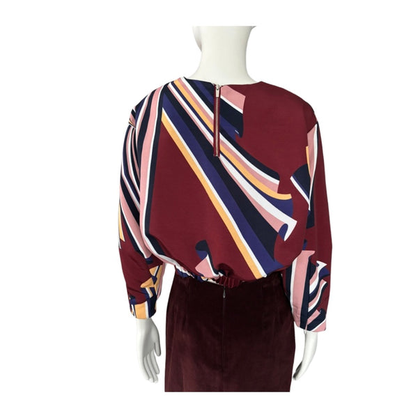 Colorful patterned dress on a mannequin against a white background