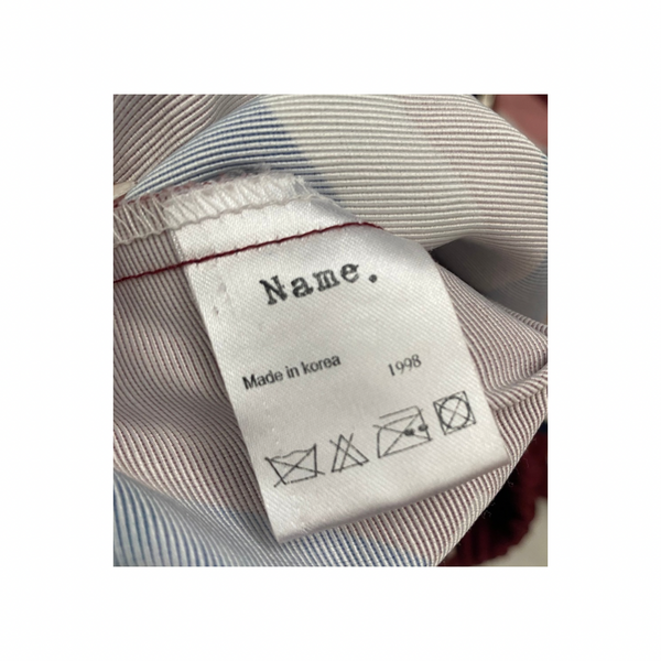 Clothing label with text and symbols on a striped fabric background