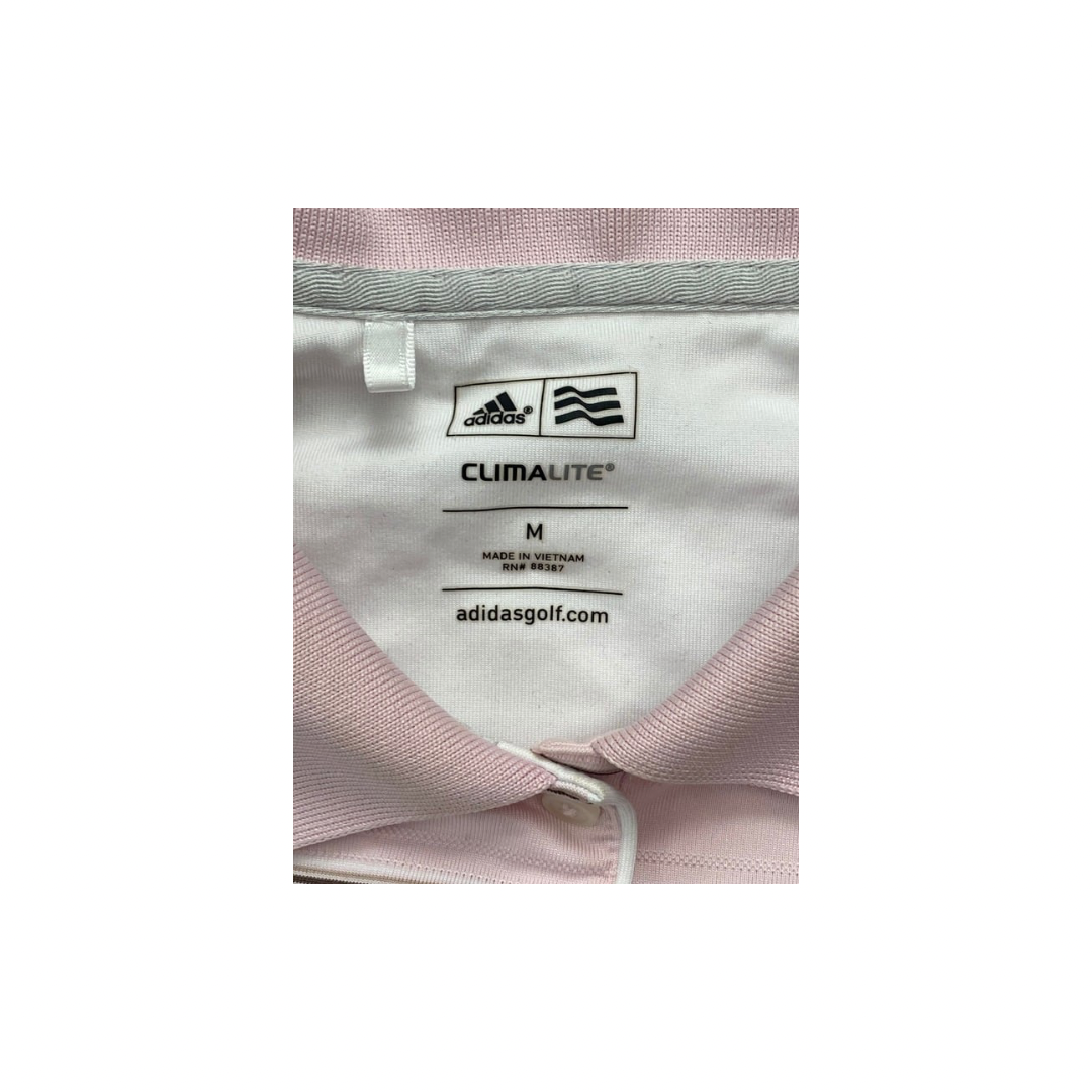 Close-up of Adidas Climalite label on a garment with pink and gray fabric.