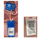 Adidas tag and label on a pink garment with visible text and symbols.