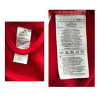 Close-up of an Adidas label on a red garment with text details.