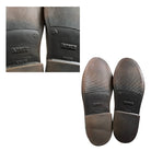 Close-up of worn leather shoes with visible brand name on sole