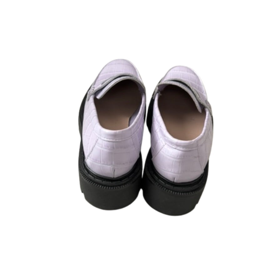 Pair of lilac shoes with black soles on a white background