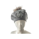 Grey knit beanie with floral design and pom-pom on a mannequin head against a white background