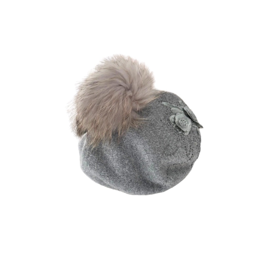 Grey knit hat with a fur pom-pom on a white background
