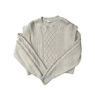 Beige cable knit sweater on a white background