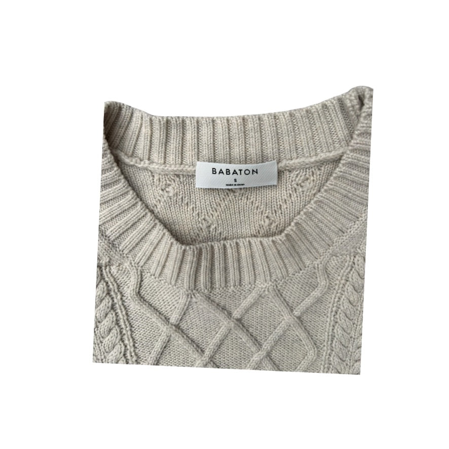 Folded gray sweater with 'Babaton' label on a white background