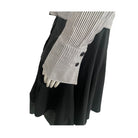 Black skirt with a white and black striped shirt on a mannequin against a white background