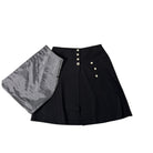 Black skirt with gray lining and white buttons on a white background