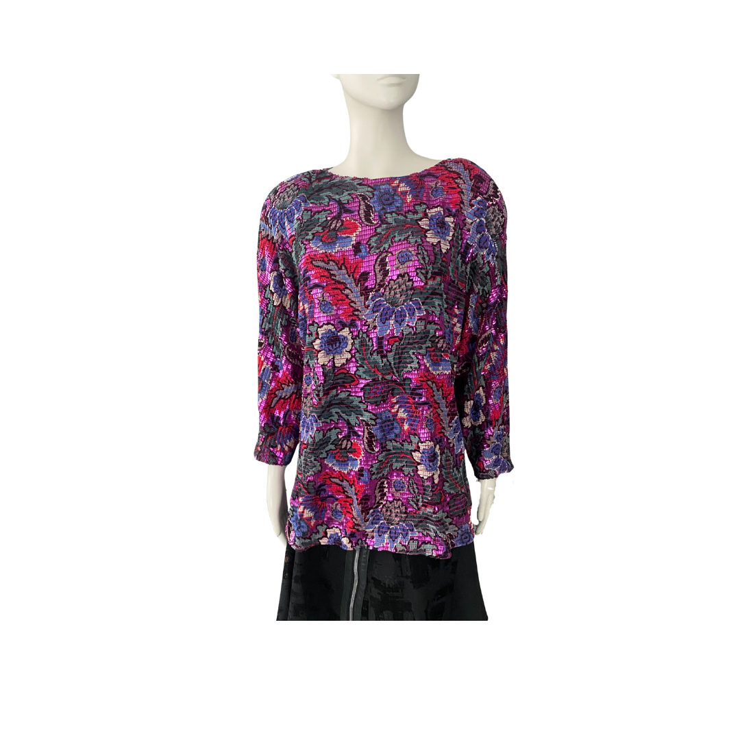 Mannequin wearing a colorful floral-patterned top on a white background