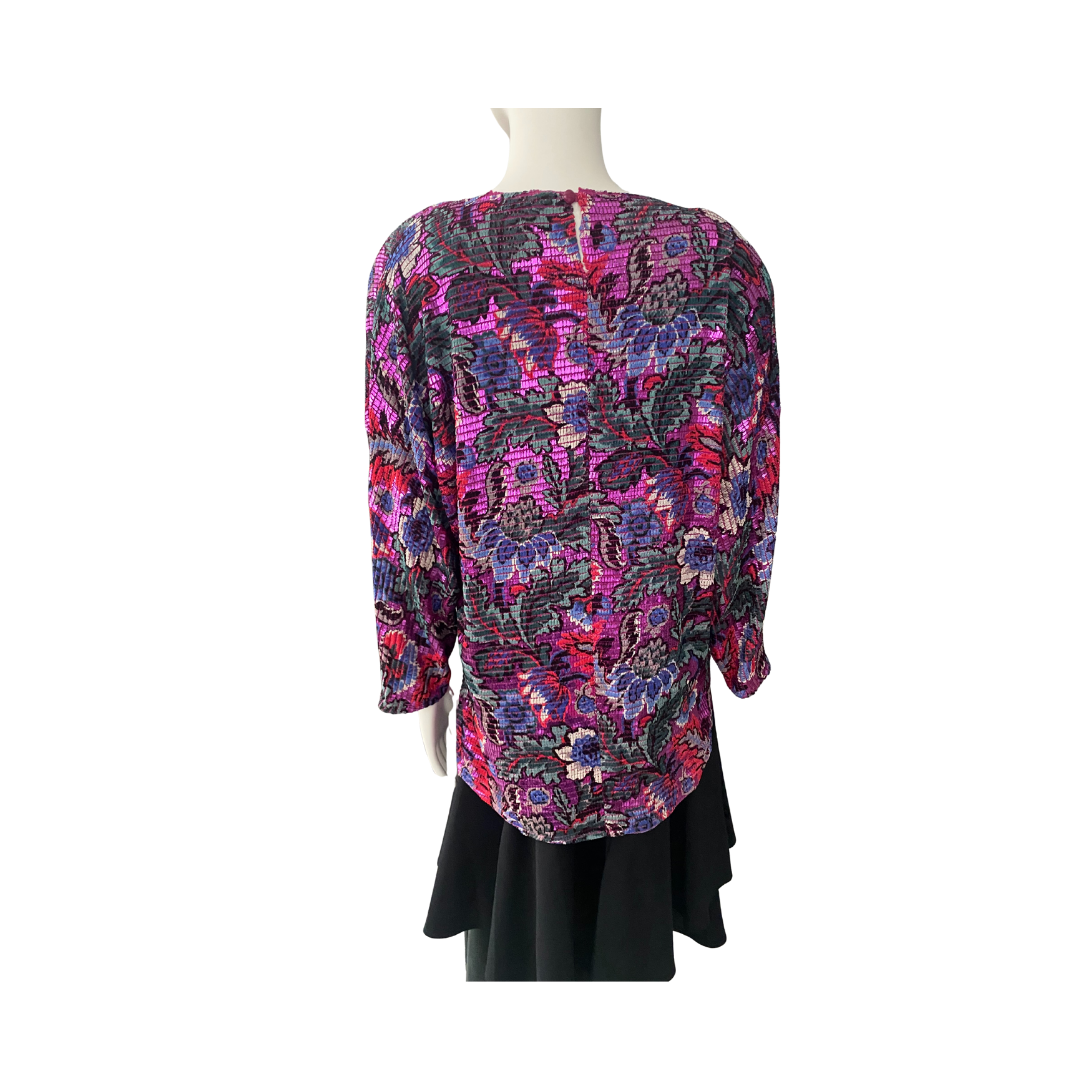 Mannequin wearing a colorful floral blouse with a black skirt on a white background