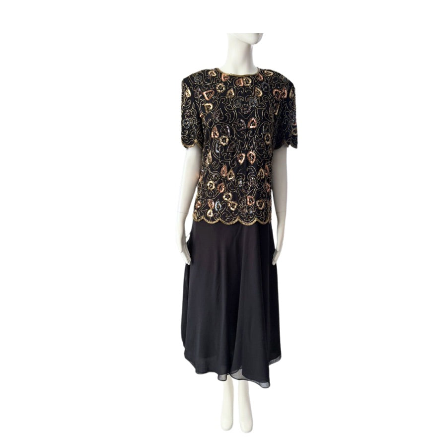 Black dress with gold lace details on a mannequin against a white background