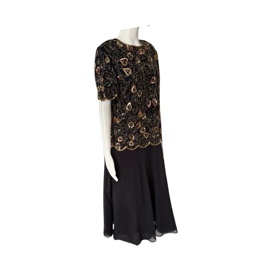 Black dress with gold embroidery on a mannequin against a white background