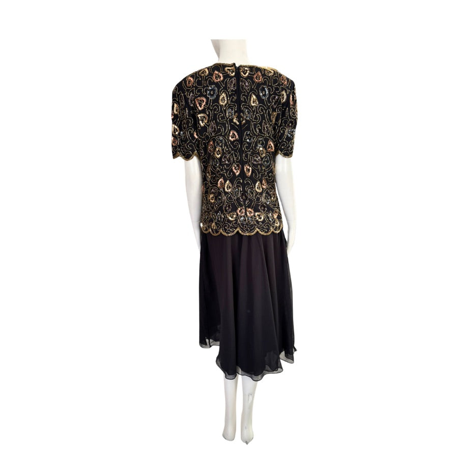 Mannequin wearing a black dress with gold floral patterns on a white background