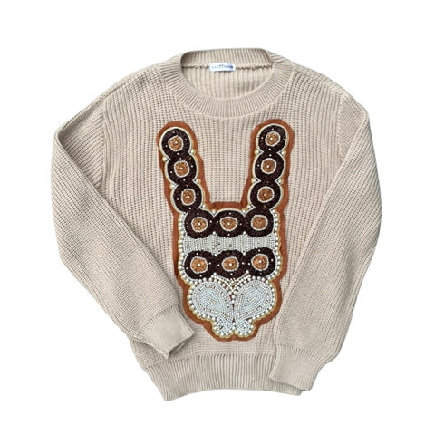 Beige sweater with decorative front panel on a white background