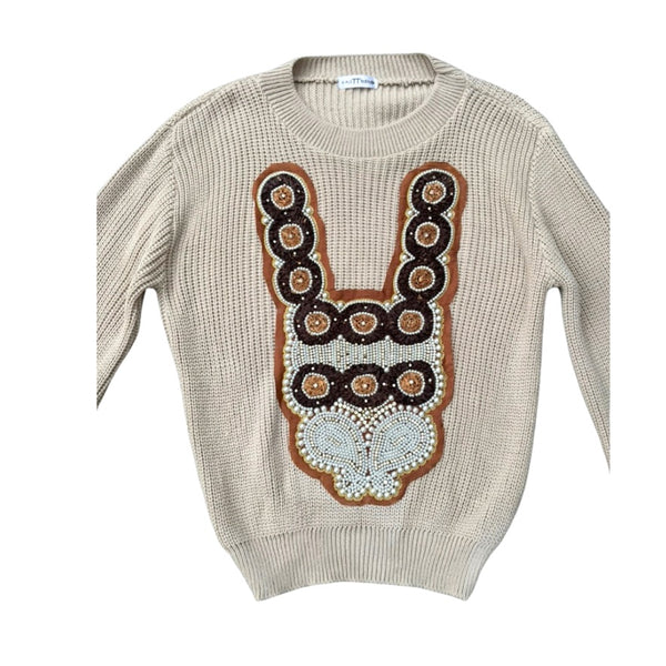 Beige sweater with decorative brown and white pattern on a white background