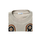 Beige sweater with brown and black embellishments on a white background