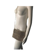 Mannequin wearing a gold studded handbag on a white background