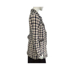 Houndstooth patterned coat on a mannequin against a white background