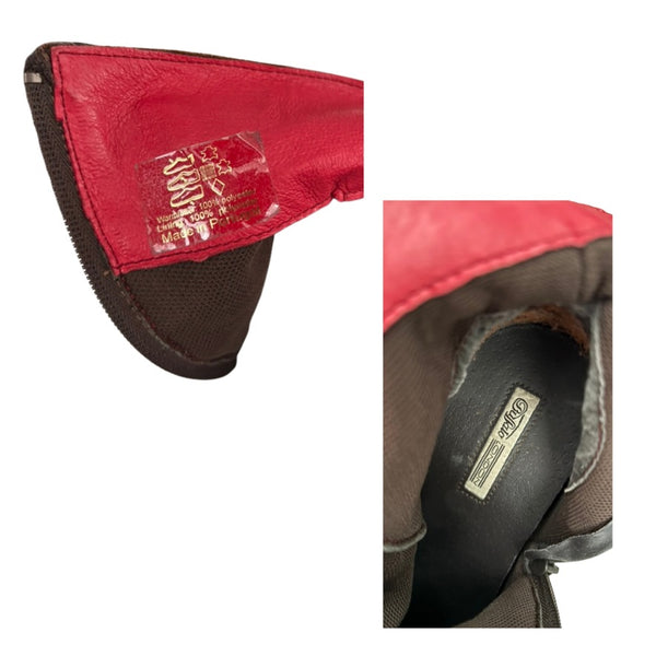 Close-up of a red and brown leather product with visible branding on a white background.