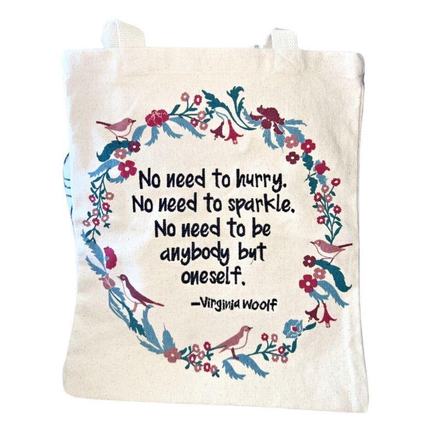 Tote bag with floral design and quote by Virginia Woolf on a white background