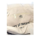 Close-up of a beige bag with a zipper and 'CDe' branding.