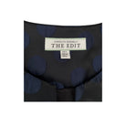 Black fabric with blue polka dots and a label reading 'The Edit' by Carolyn Donnelly on a white background.