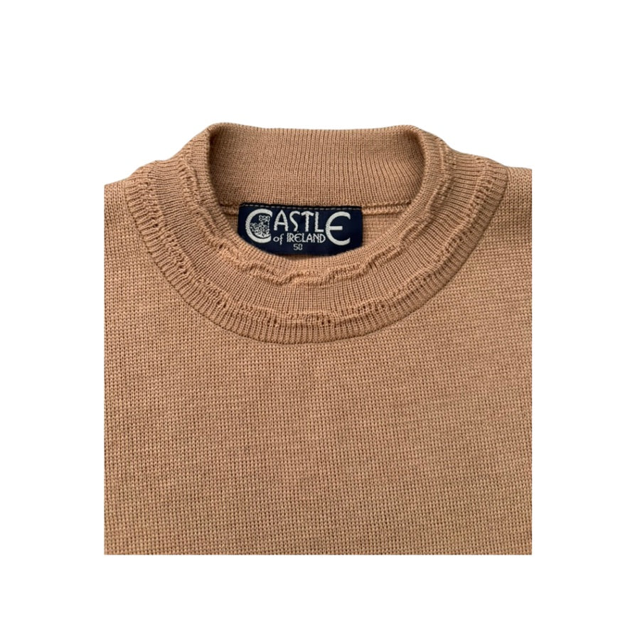 Folded beige sweater with 'Castle of Ireland' label on a white background