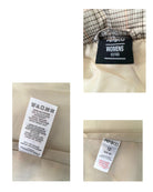 Close-up of clothing tags with brand names on a beige fabric background