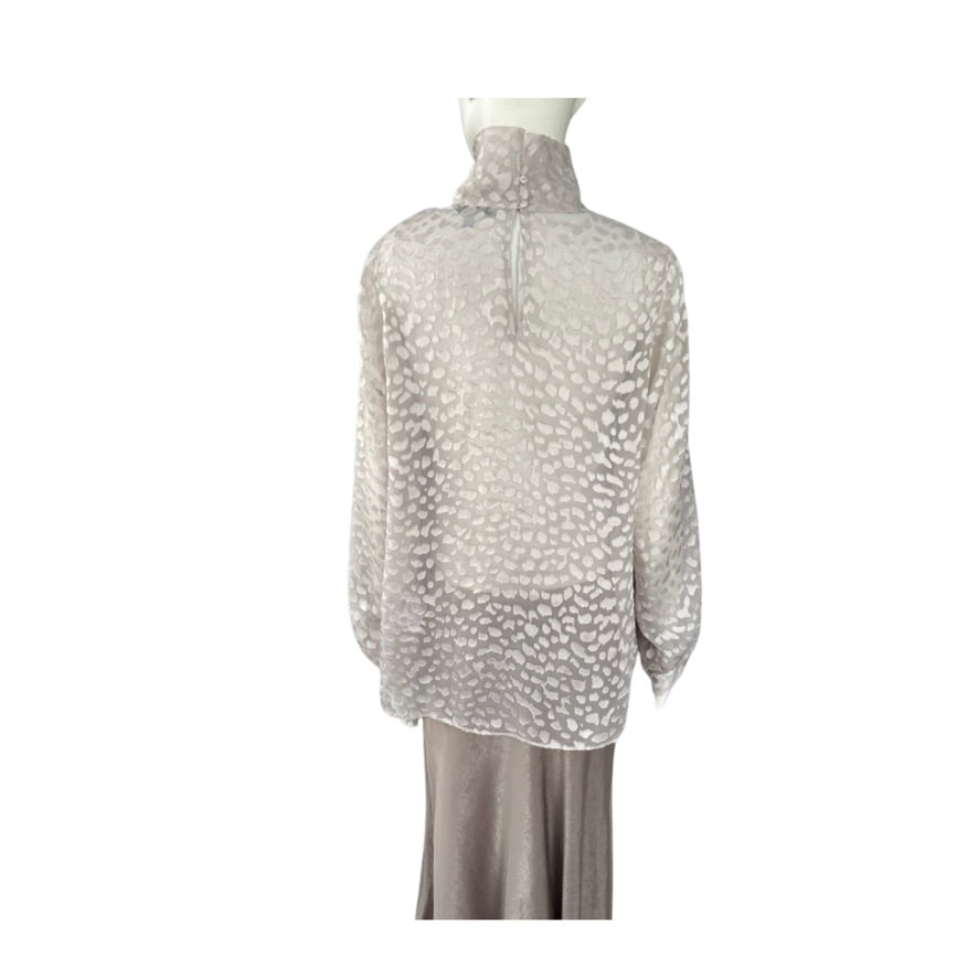 Sheer blouse with a pattern on a mannequin against a white background